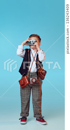 Young boy photographing with vintage camera collection. Young boy photographing with vintage camera collection. 136243409