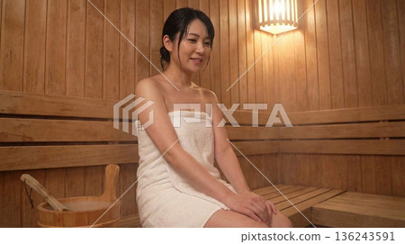 Woman sweating in a sauna 136243591