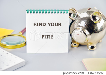 A white spiral notepad features the bold text Find Your Fire placed upright on a clean gray desk A white spiral notepad features the bold text Find Your Fire placed upright on a clean gray desk 136243597
