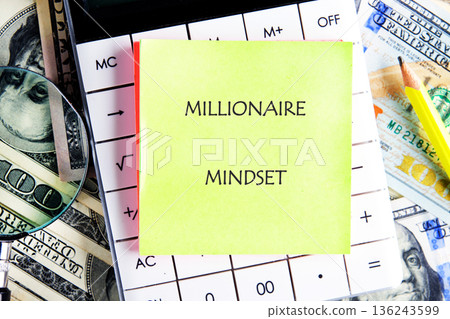 Bright yellow sticky note displays Millionaire Mindset on a calculator 136243599