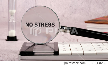 A magnifying glass rests on a calculator, clearly showing the words NO STRESS A magnifying glass rests on a calculator, clearly showing the words NO STRESS 136243642