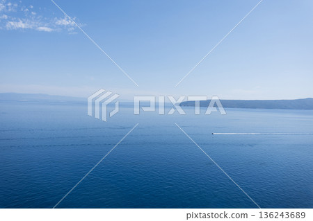 Peaceful seascape with gentle waves and wide horizon under a clear sky in Croatia. Beautiful sea view with blue sky and islands. Summer vacation 136243689