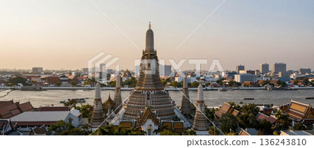 Aerial wide angle view of Wat Arun temple overlooking Bangkok city and Chao Phraya River at golden hour 136243810