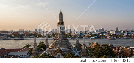 Aerial wide angle view of Wat Arun temple overlooking Bangkok city and Chao Phraya River at golden hour 136243812