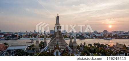 Aerial wide angle view of Wat Arun temple overlooking Bangkok city and Chao Phraya River at golden hour 136243813