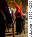 Detailed view of a hand holding a large lit candle in a religious procession 136244239