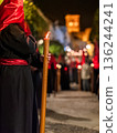 Detailed view of a hand holding a large lit candle in a religious procession 136244241