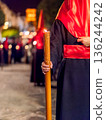 Detailed view of a hand holding a large lit candle in a religious procession 136244242