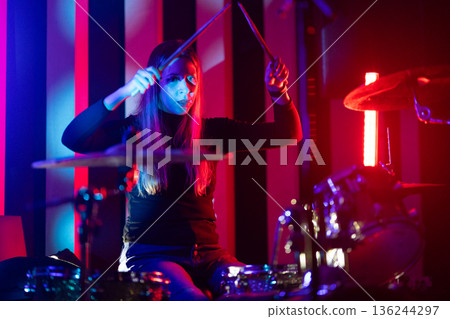 Female drummer playing drums during a live performance 136244297
