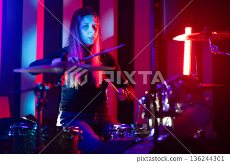 Woman drummer playing live music on stage 136244301