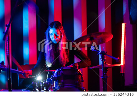 Woman drummer performing live music on stage 136244316