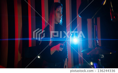 Female drummer playing live music with bright light Female drummer playing live music with bright light 136244336