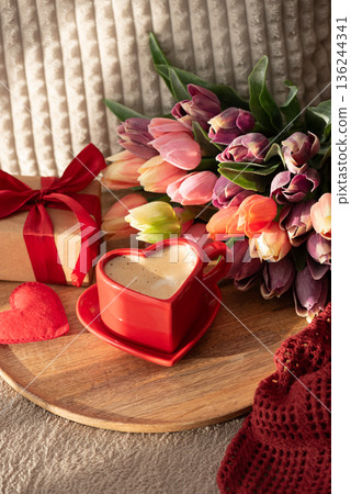 Top View Heart Shaped Coffee Cup with Colorful Tulips and Candies. Cozy Romantic Flatlay on Sofa for Valentines Day Celebration Top View Heart Shaped Coffee Cup with Colorful Tulips and Candies. Cozy Romantic Flatlay on Sofa for Valentines Day Celebration 136244341
