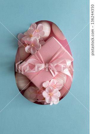 Easter Gift Box with Decorated Eggs and Blossoms in Heart Cutout. Festive Spring Flatlay on Blue Background 136244350
