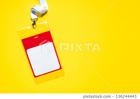 Minimalist name badge with copy space, suspended by a white lanyard. Red and yellow accents on a yellow backdrop. Perfect for conference, event, or office ID visuals 136244443