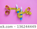 Insulin injection pens and measuring tape on pink surface. Concept of obesity control, diabetes care, and modern medication. drugs injection ozempic for weight loss 136244449