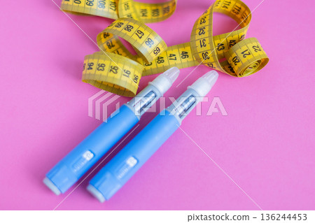 Medical devices for diabetes with tape measure on pink. Illustration of weight loss, insulin therapy, and chronic illness treatment. drugs injection ozempic for weight loss Medical devices for diabetes with tape measure on pink. Illustration of weight loss, insulin therapy, and chronic illness treatment. drugs injection ozempic for weight loss 136244453
