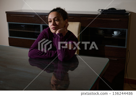 Thoughtful Woman At The Dining Table In A Quiet Room Reflecting On Life 136244486