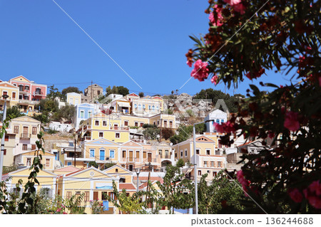 Multi-colored houses on the shore of the ancient harbor on the island of Simi, Greece Multi-colored houses on the shore of the ancient harbor on the island of Simi, Greece 136244688