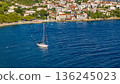 White sailboat on calm Adriatic waters near coastal town in Croatia summer scene aerial view 136245023
