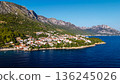 Aerial view of Croatian seaside town with red roofs and rocky coastline on Adriatic Sea 136245026