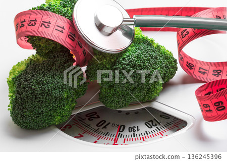 Broccoli with measuring tape on weight scale. Dieting 136245396