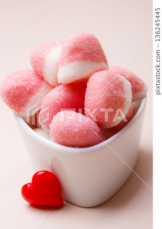 Pink jellies or marshmallows with sugar in bowl Pink jellies or marshmallows with sugar in bowl 136245445