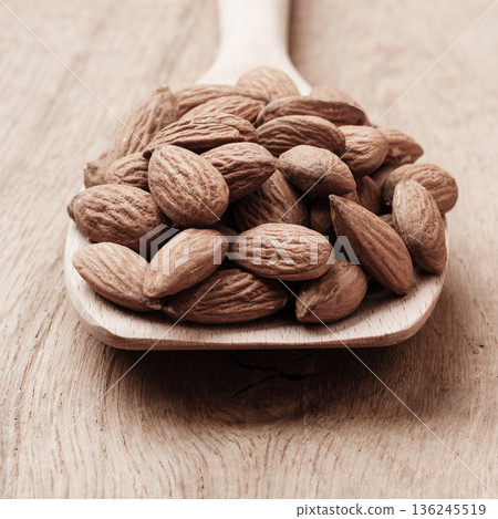 Almonds on wooden spoon Almonds on wooden spoon 136245519