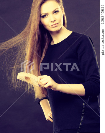 Long haired girl combing her beauty hair. 136245635