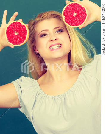 Woman holds grapefruit citrus fruit in hands Woman holds grapefruit citrus fruit in hands 136245828