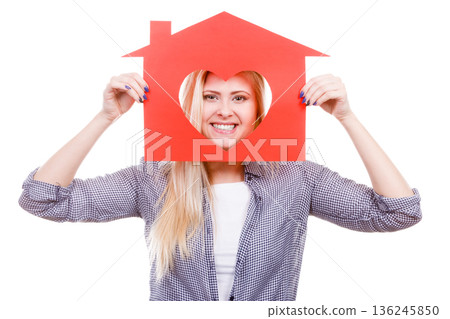 Smiling girl holding red paper house with heart shape 136245850