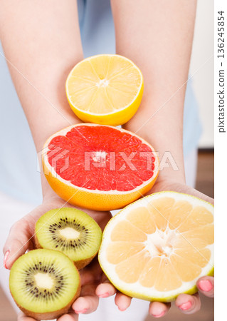 Woman holding fruits kiwi. orange, lemon and grapefruit Woman holding fruits kiwi. orange, lemon and grapefruit 136245854