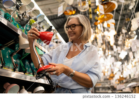 Shopping for modern desk lamps in a home goods store during the day 136246152