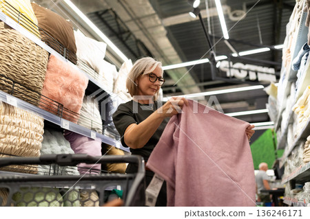 Woman shopping for soft textiles in a home goods store during a weekend afternoon Woman shopping for soft textiles in a home goods store during a weekend afternoon 136246171