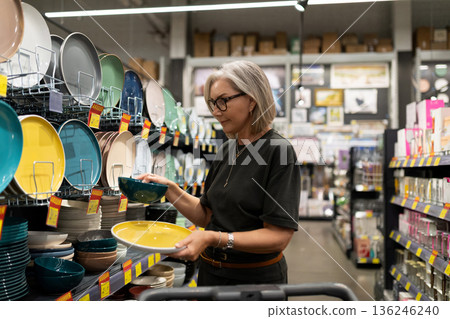 Shopping for colorful dishes in a store during the afternoon with various plates and bowls on 136246240