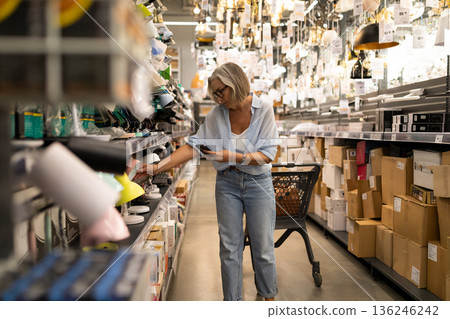 Shopping for home decor in a store filled with various light fixtures and accessories during a Shopping for home decor in a store filled with various light fixtures and accessories during a 136246242