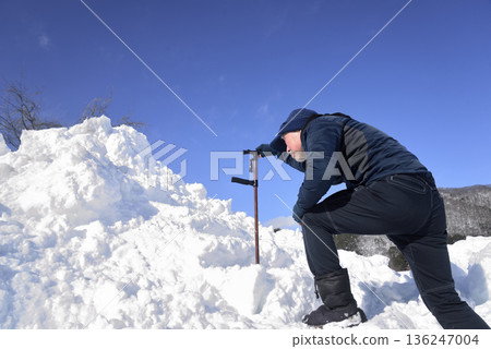 An elderly man undergoing rehabilitation by using a cane to go up and down snowy stairs An elderly man undergoing rehabilitation by using a cane to go up and down snowy stairs 136247004