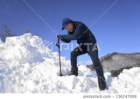 An elderly man undergoing rehabilitation by using a cane to go up and down snowy stairs An elderly man undergoing rehabilitation by using a cane to go up and down snowy stairs 136247008
