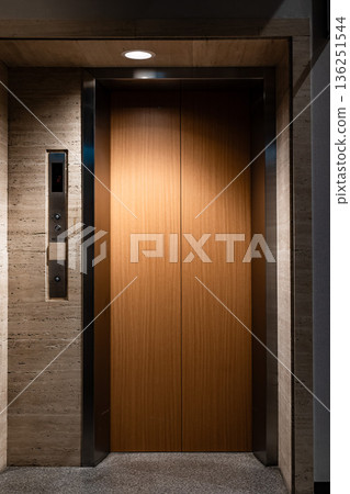 A luxurious architectural space with wood-grain elevator doors and modern interior A luxurious architectural space with wood-grain elevator doors and modern interior 136251544
