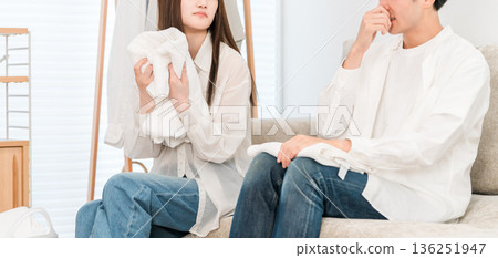 A couple folding laundry in the living room (damp, damp smell, drying indoors) A couple folding laundry in the living room (damp, damp smell, drying indoors) 136251947