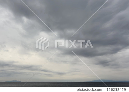 Calm seascape covered with low clouds Calm seascape covered with low clouds 136252459