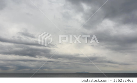 Gray sky with thick clouds and a calm sea Gray sky with thick clouds and a calm sea 136252462