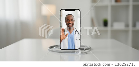 African american male doctor talking to patient during app video call on smartphone with stethoscope on white table, representing modern telehealth and online medical consultation African american male doctor talking to patient during app video call on smartphone with stethoscope on white table, representing modern telehealth and online medical consultation 136252713