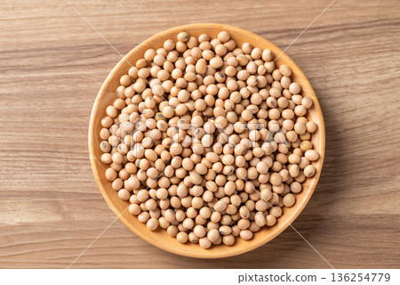 Top view of raw organic soybeans in a wooden bowl on a rustic wooden table 136254779