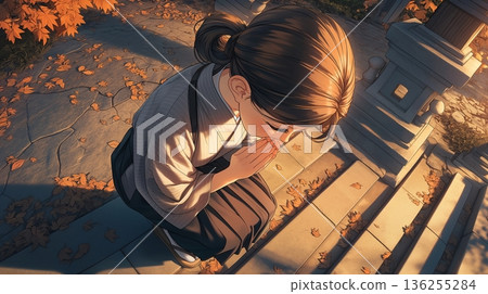 一位女子在秋葉環繞的神社許願。 一位女子在秋葉環繞的神社許願。 136255284