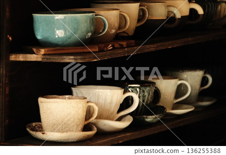 Ceramic coffee cups lined up on shelves in a cafe Ceramic coffee cups lined up on shelves in a cafe 136255388