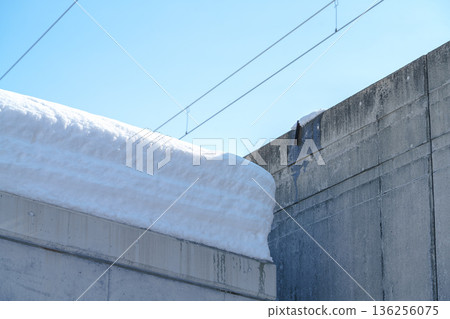 Snow piled up on a concrete roof Snow piled up on a concrete roof 136256075