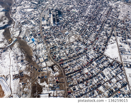 Aerial drone shot of a snow covered town with grid street layout Aerial drone shot of a snow covered town with grid street layout 136259015