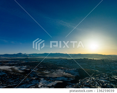 A beautiful blue sky with a sun setting in the distance 136259039