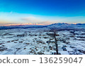 A snowy landscape with a city in the distance 136259047